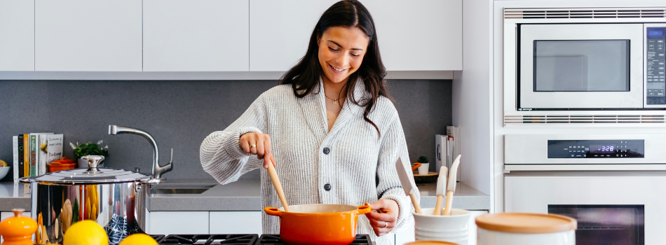 Femme dans la cuisine en train de prépare un plat.